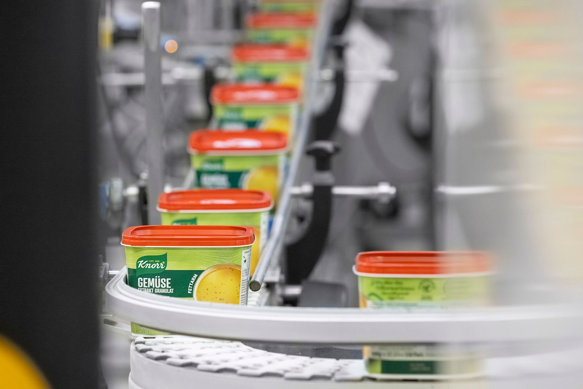 A conveyor belt filled with containers of buillon at Unilever.