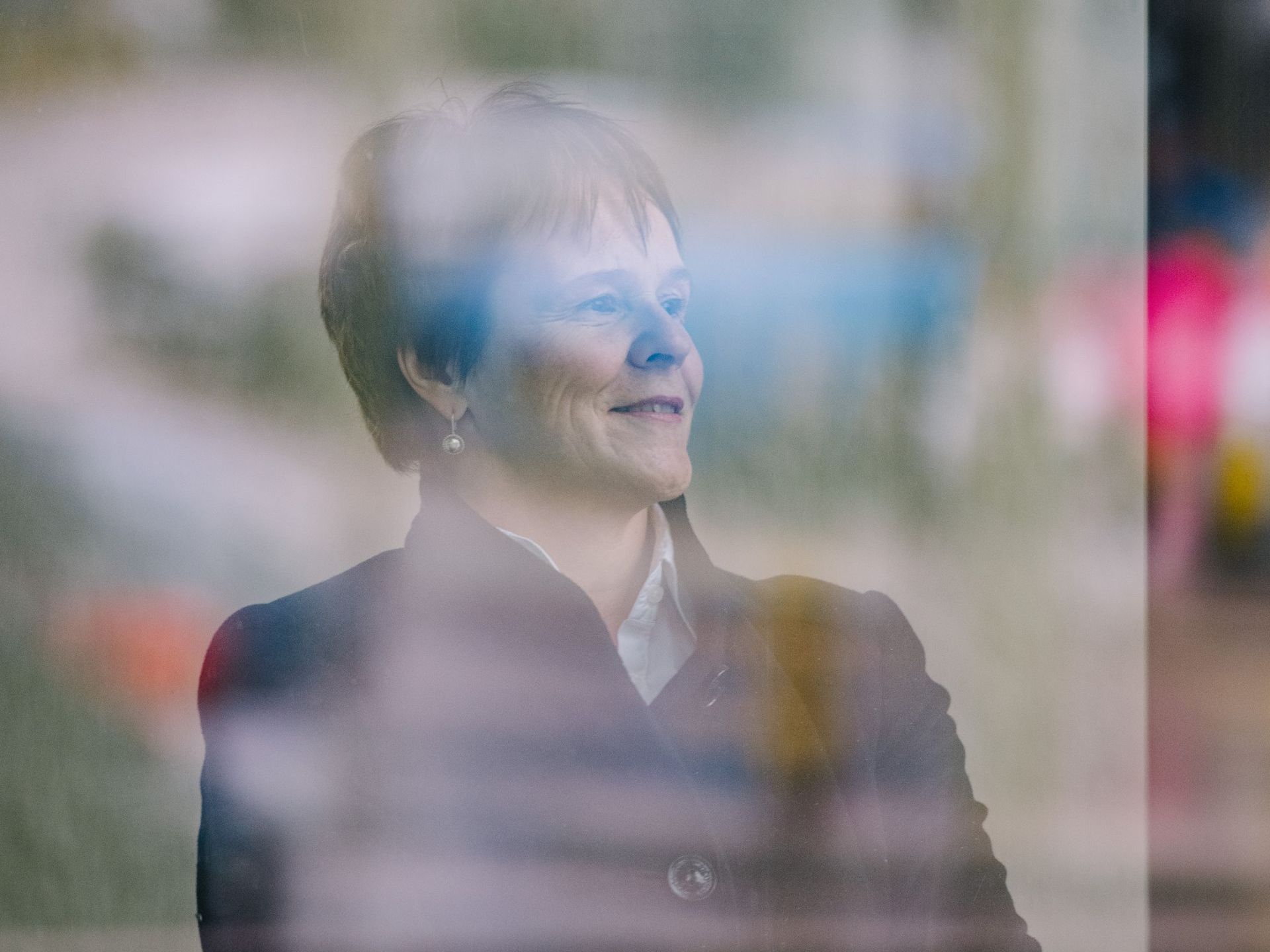 Eine Frau schaut aus einem Fenster und lächelt.