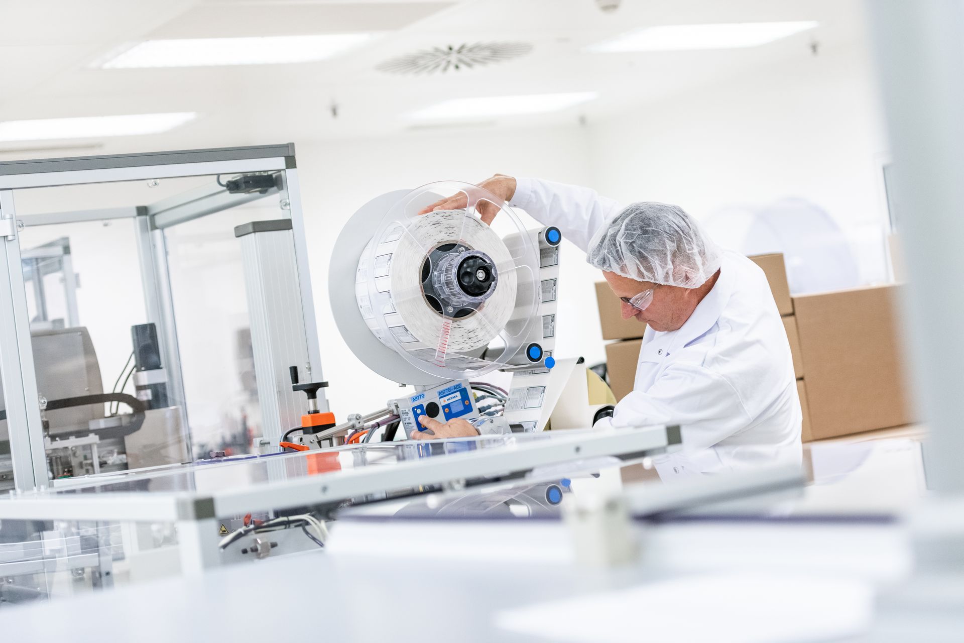 A man is working on a machine in a clean room.