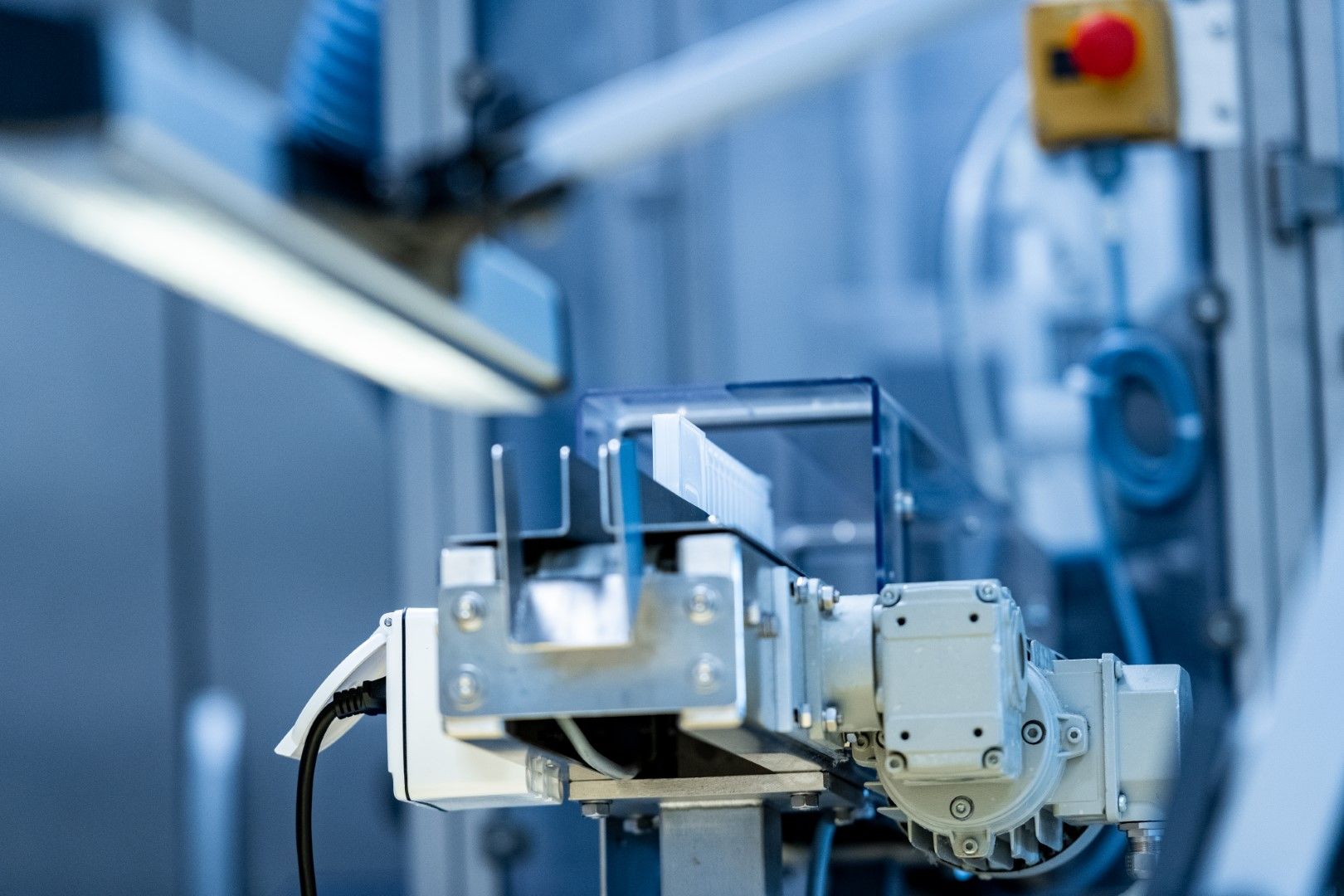 A machine is sitting on top of a conveyor belt in a factory.