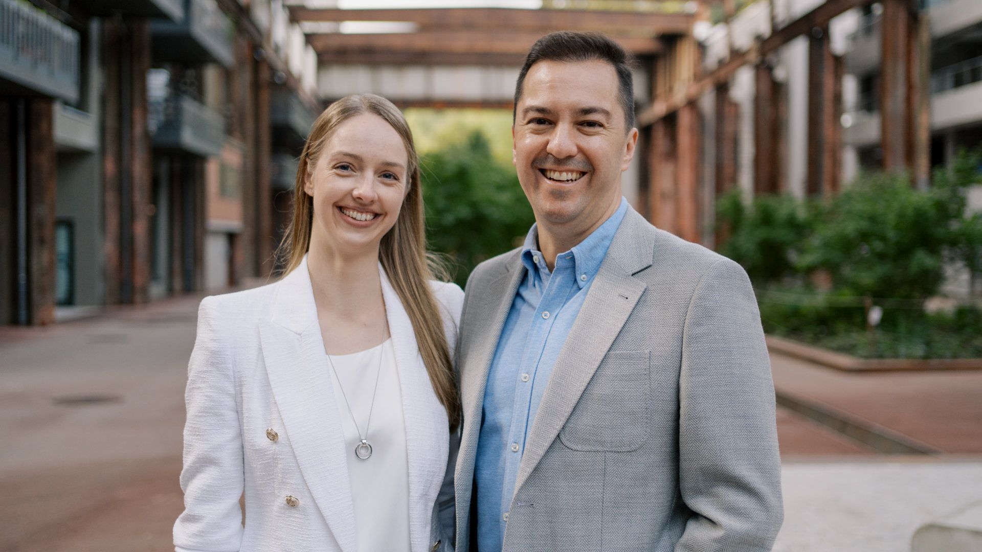 A man and a woman are standing next to each other in front of a building.