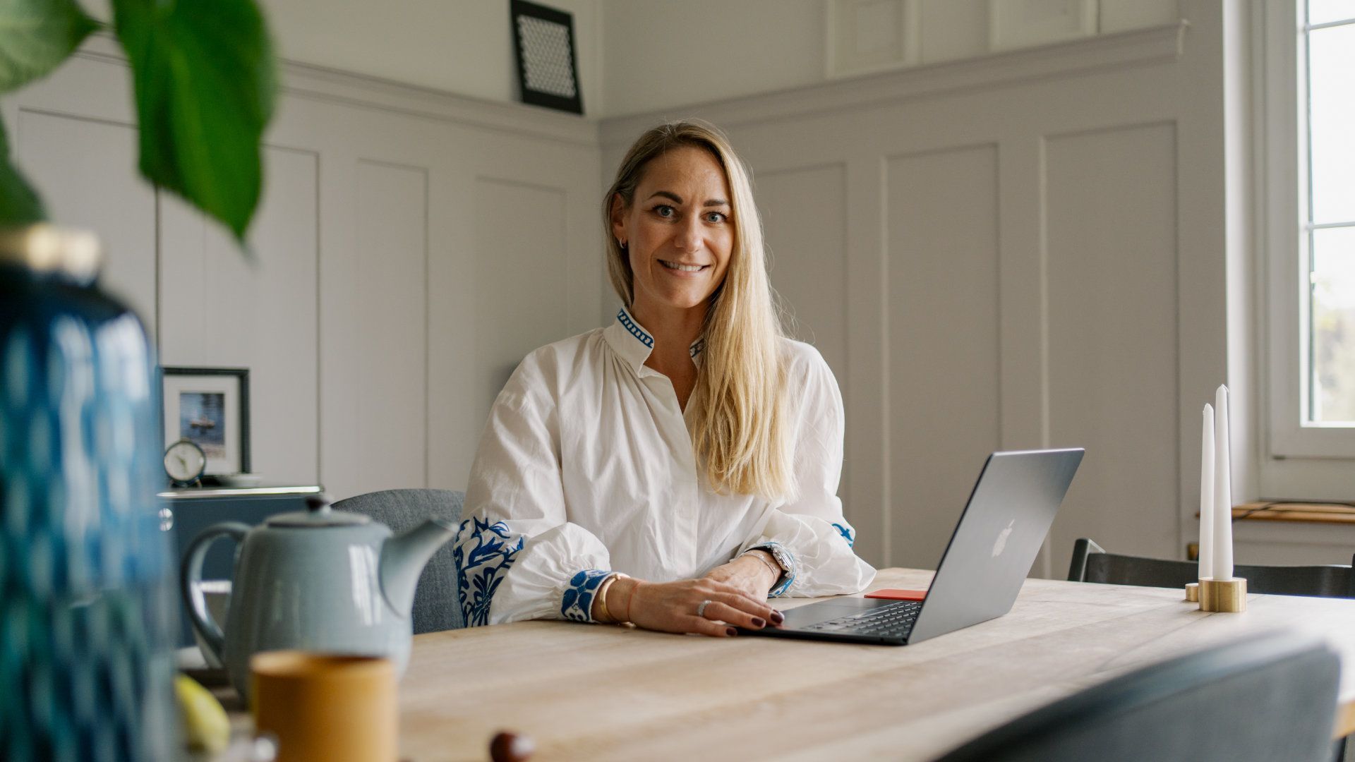 A woman is sitting at a table with a laptop computer.