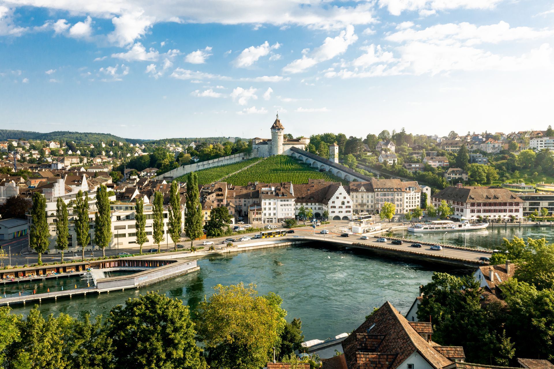 An aerial view of Schaffhausen, Switzerland with a bridge over the rhine and the Munot castle in the background.